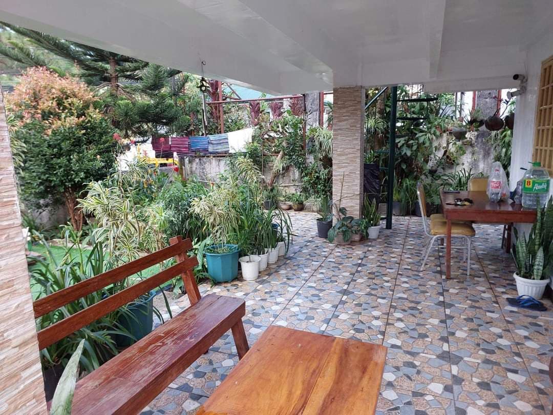 Open-air patio surrounded by lush garden plants